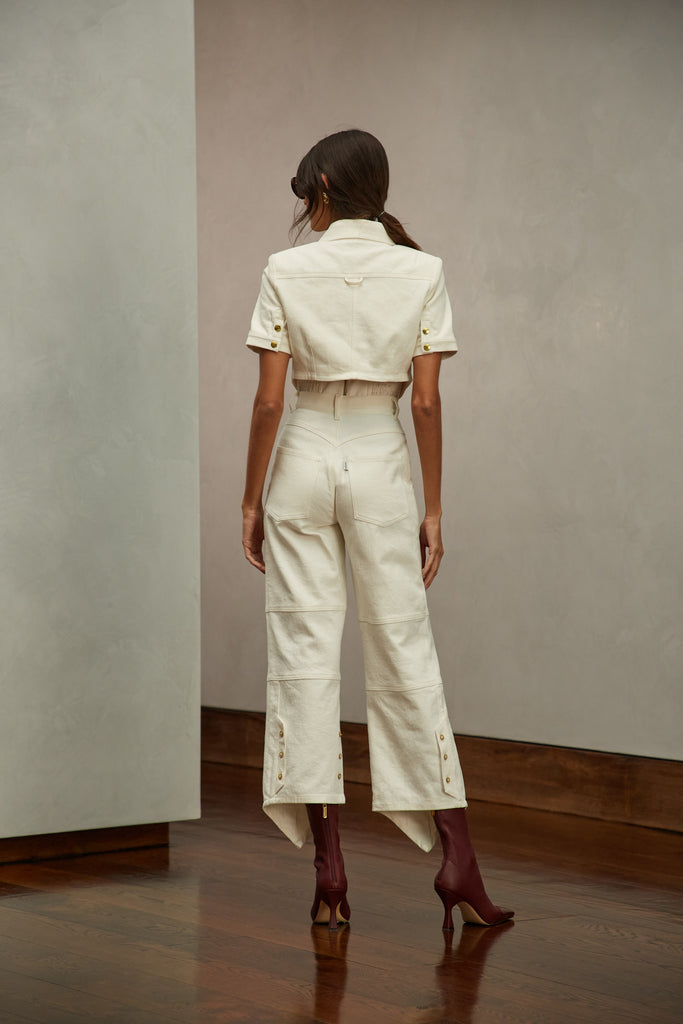 Bone Quinn Bolero This cropped stretch cotton denim bolero, designed to feel weightless and breathable during all seasons features an asymmetrical curved hem and light shoulder pads for a structured look. Style with The Sarah Stretch Jean | The Quinn Jean | The Chloe Corset