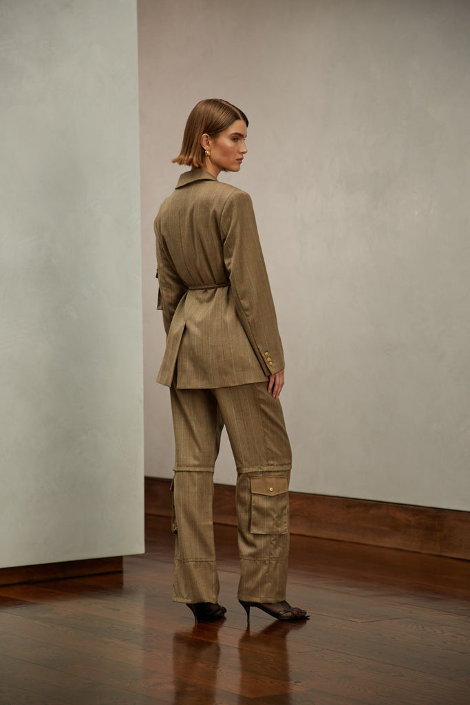 Camel Herringbone Ronnie Blazer Oversized 90's inspired blazer featuring a fixed self-fabric waist tie, cargo pocket detail on left sleeve, two standard flap pockets at hips, and custom selected horn buttons. Ana is 5'9