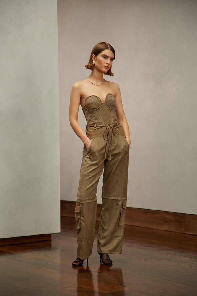 Camel Herringbone Ronnie Trouser High-rise lightweight tailored trouser featuring contrasting waistband with self-fabric tie tunneled through two rows of belt loops. Featuring a relaxed leg fit with cargo style pockets and horn buttons. Ana is 5'9