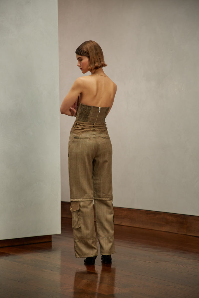 Camel Herringbone Ronnie Trouser High-rise lightweight tailored trouser featuring contrasting waistband with self-fabric tie tunneled through two rows of belt loops. Featuring a relaxed leg fit with cargo style pockets and horn buttons. Ana is 5'9