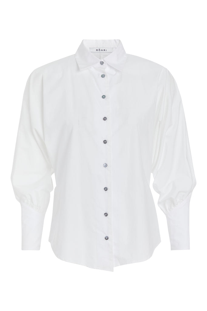 White Marna Poplin Shirt Classic tailored button-up shirt in midweight 100% Supima cotton. Featuring blousoned dolman sleeves with, Mother of Pearl buttons down center front placket, and concelead zippers at wrists with reverse V cut cuff details.