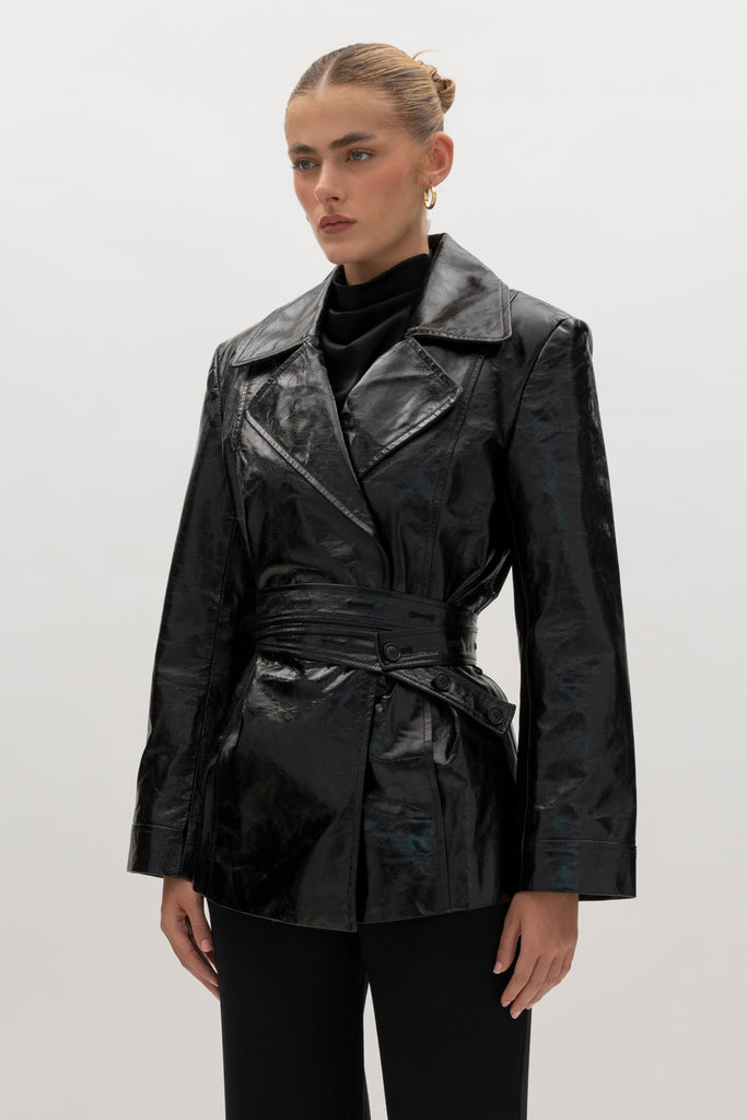 Black Kennedy Trench Crafted from 100% glazed cow leather, the Kennedy trench showcases sharp collars and clean lines. The cinched waist with buttoned belt offers a customizable fit.-100% glazed cow leather trench -Hidden stay button closure-Double wrap belt-Bracelet-length sleeve-On seam front pockets-Fully lined Handcrafted in small batches by our expert leather artisan in New York City.We recommend sizing up if a relaxed fit is desired otherwise choose your usual size.Styled with the Vivien LS Top & Mia Trouser