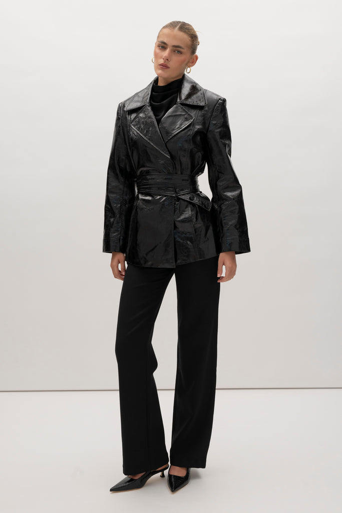 Black Kennedy Trench Crafted from 100% glazed cow leather, the Kennedy trench showcases sharp collars and clean lines. The cinched waist with buttoned belt offers a customizable fit.-100% glazed cow leather trench -Hidden stay button closure-Double wrap belt-Bracelet-length sleeve-On seam front pockets-Fully lined Handcrafted in small batches by our expert leather artisan in New York City.We recommend sizing up if a relaxed fit is desired otherwise choose your usual size.Styled with the Vivien LS Top & Mia Trouser