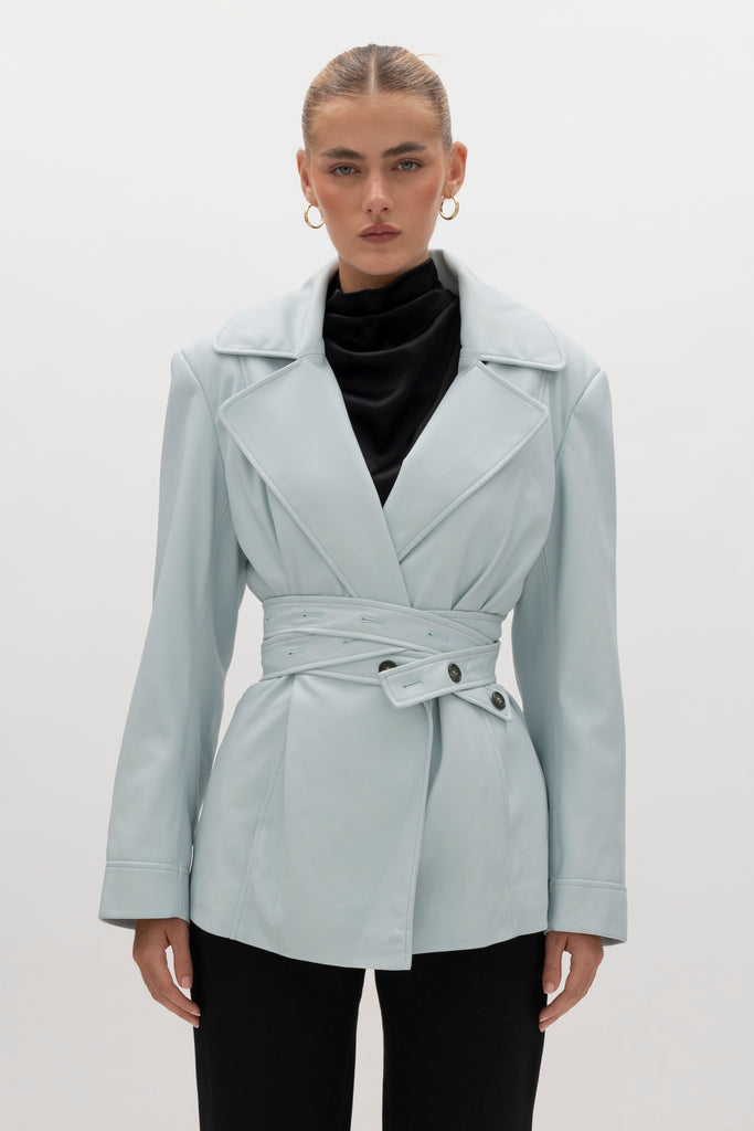 Powder Blue Kennedy Trench Handcrafted from soft vegan leather, the Kennedy trench showcases sharp collars and clean lines. The cinched waist with buttoned belt offers a customizable fit.-Hidden stay button closure-Double wrap belt-Bracelet-length sleeve-On seam front pockets-Fully lined Handcrafted in small batches by our expert leather artisan in New York City.We recommend sizing up if a relaxed fit is desired otherwise choose your usual size.Styled with the Vivien LS Top & Mia Trouser