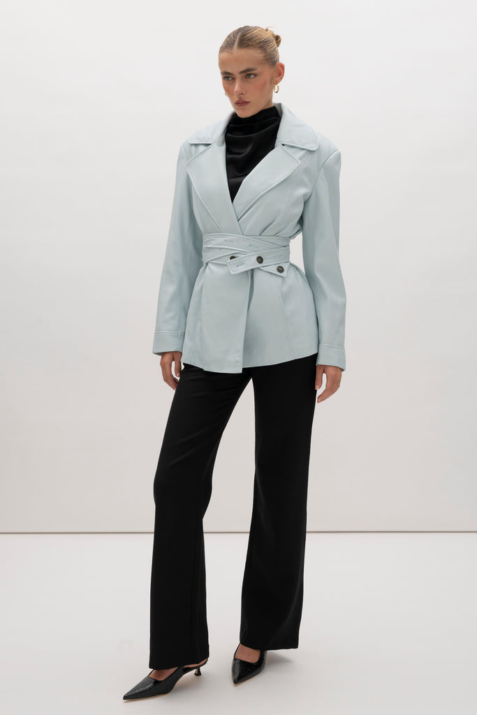 Powder Blue Kennedy Trench Handcrafted from soft vegan leather, the Kennedy trench showcases sharp collars and clean lines. The cinched waist with buttoned belt offers a customizable fit.-Hidden stay button closure-Double wrap belt-Bracelet-length sleeve-On seam front pockets-Fully lined Handcrafted in small batches by our expert leather artisan in New York City.We recommend sizing up if a relaxed fit is desired otherwise choose your usual size.Styled with the Vivien LS Top & Mia Trouser