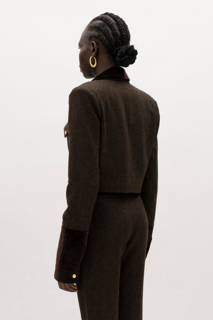 Brown Herringbone Camilo Jacket The Camilo Jacket: A fusion of classic tailoring and refined detailing, this cropped jacket elevates timeless tweed with modern touches.-Cropped herringbone blazer -Soft Merino wool-Contrast velvet combo fabric at the collar and lapel-Flap pocket with single gold knot button closure-Structured padded shoulder -Gold knot buttons at center front-Gold knot button on exterior cuff-Fully lined Crafted with Merino wool certified by the Wool Integrity Programme, ensuring farms adhere to the Five Freedoms of animal welfare. We recommend ordering your usual size.Styled with the Raymond Trouser, Zoey Tank, & Kate Short