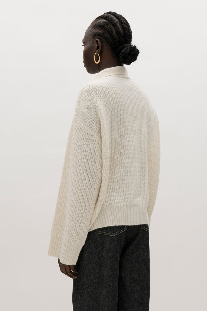 Bone Graham Cardigan This 100% royal cashmere cardigan features an oversized silhouette that hits below the hip, perfect for layering. Features horn buttons along with pockets at chest and right sleeve. Can be worn open or buttoned up as a turtleneck.We recommend ordering your usual size.Styled with the Jane Jean