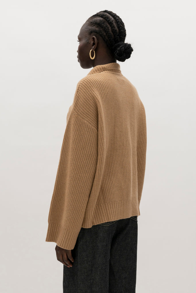 Creme Brulee Graham Cardigan This 100% royal cashmere cardigan features an oversized silhouette that hits below the hip, perfect for layering. Features horn buttons along with pockets at chest and right sleeve. Can be worn open or buttoned up as a turtleneck.We recommend ordering your usual size.Styled with the Jane Jean
