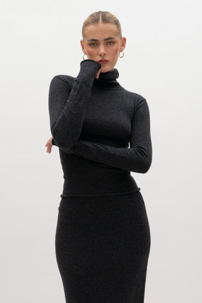 Charcoal Olivia Turtleneck Delicately soft and consciously crafted, it's the perfect foundation for any outfit.-Classic turtleneck silhouette -Extra-long neck trim for versatile styling (folding and stacking)-Long sleeves designed for slight stacking at the wrist-Rolled wrist and bottom hem 🐑 Made with Good Cashmere Standard® wool to support the welfare of cashmere goats We recommend ordering your usual size.Styled with the Ava Skirt