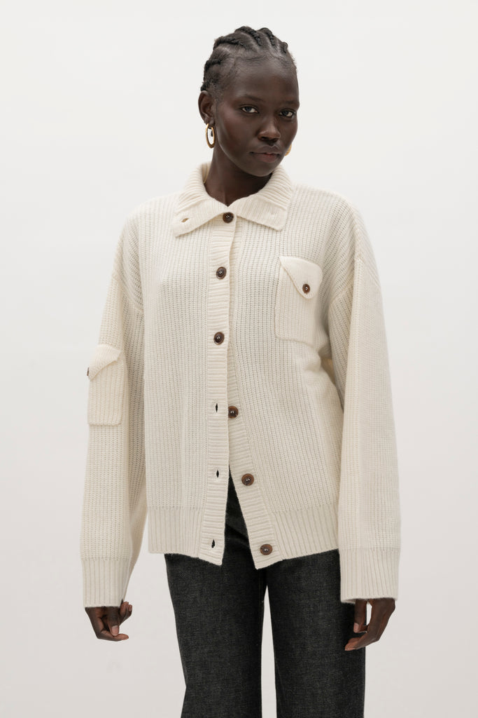Bone Graham Cardigan This 100% royal cashmere cardigan features an oversized silhouette that hits below the hip, perfect for layering. Features horn buttons along with pockets at chest and right sleeve. Can be worn open or buttoned up as a turtleneck.We recommend ordering your usual size.Styled with the Jane Jean