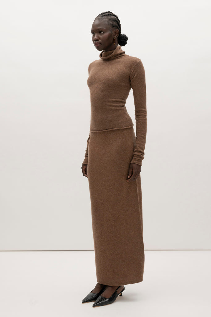 Brown Olivia Turtleneck Delicately soft and consciously crafted, it's the perfect foundation for any outfit.-Classic turtleneck silhouette -Extra-long neck trim for versatile styling (folding and stacking)-Long sleeves designed for slight stacking at the wrist-Rolled wrist and bottom hem 🐑 Made with Good Cashmere Standard® wool to support the welfare of cashmere goats We recommend ordering your usual size.Styled with the Ava Skirt