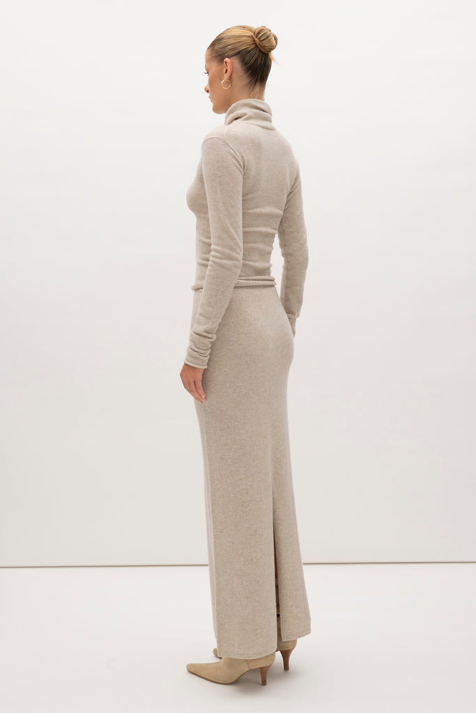 Oatmeal Olivia Turtleneck Delicately soft and consciously crafted, it's the perfect foundation for any outfit.-Classic turtleneck silhouette -Extra-long neck trim for versatile styling (folding and stacking)-Long sleeves designed for slight stacking at the wrist-Rolled wrist and bottom hem 🐑 Made with Good Cashmere Standard® wool to support the welfare of cashmere goats We recommend ordering your usual size.Styled with the Ava Skirt