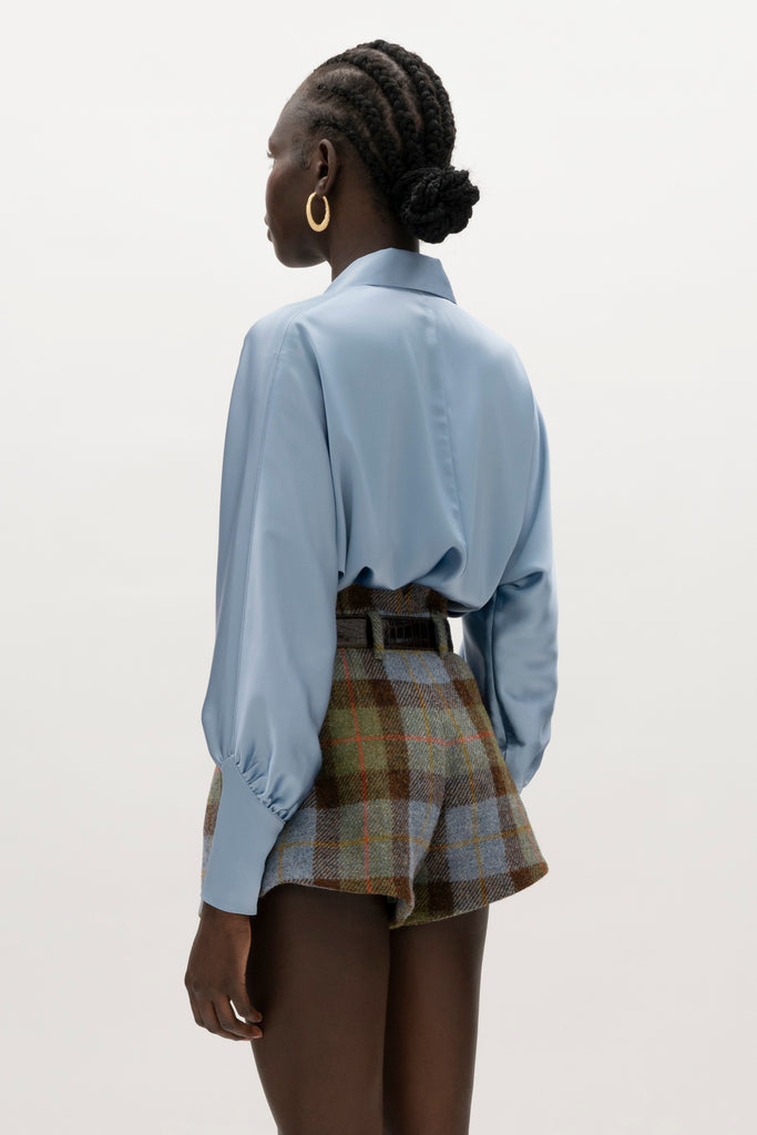 Sky Marna Shirt -Satin button front shirt with dolman sleeves-Structured collar with top and bottom edge stitching-Tailored cuffs with invisible side zippers-Removable self-covered shoulder pads-Finished with refined interior details and minimal visible stitching-Mother of pearl buttons-Wrinkle-resistant recycled satin We recommend ordering your usual size.Styled with the Kate Short