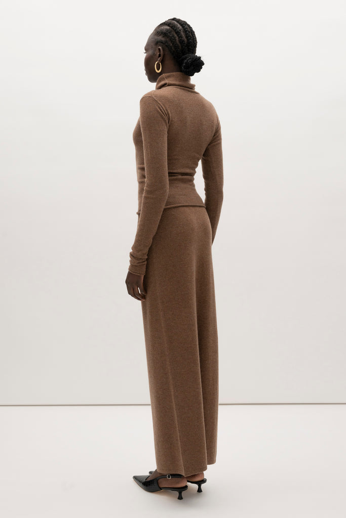 Brown Olivia Turtleneck Delicately soft and consciously crafted, it's the perfect foundation for any outfit.-Classic turtleneck silhouette -Extra-long neck trim for versatile styling (folding and stacking)-Long sleeves designed for slight stacking at the wrist-Rolled wrist and bottom hem 🐑 Made with Good Cashmere Standard® wool to support the welfare of cashmere goats We recommend ordering your usual size.Styled with the Ava Skirt