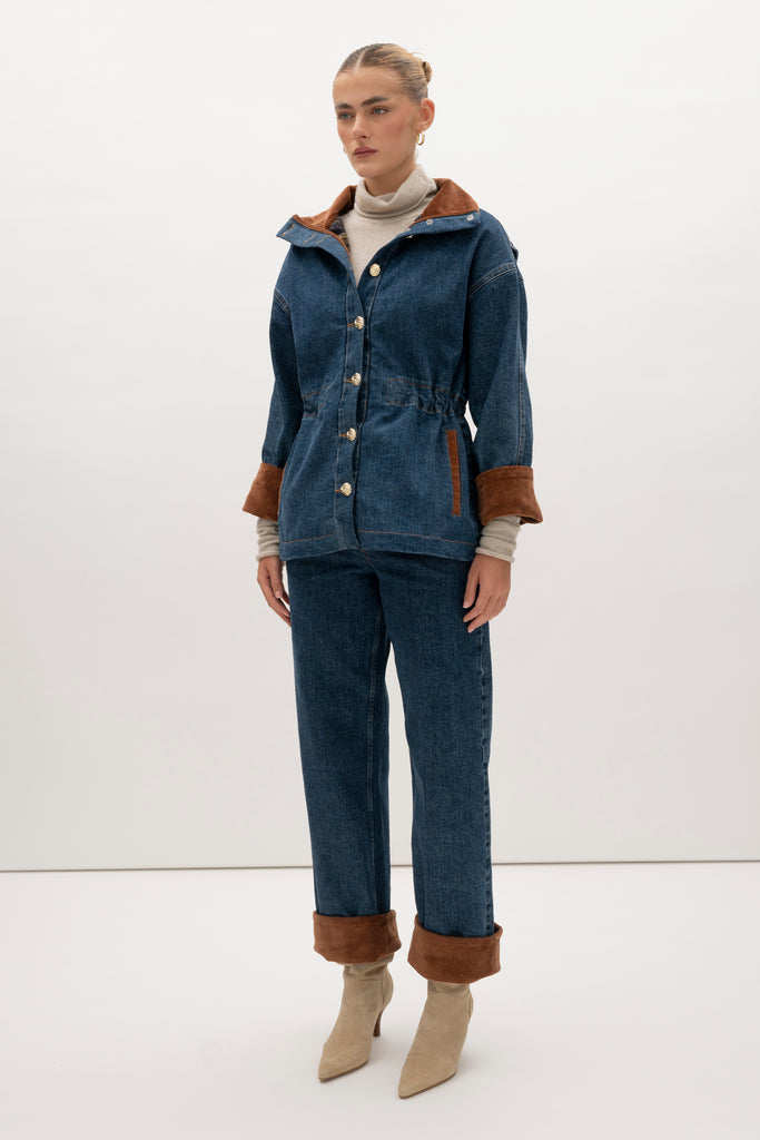 Medium Indigo Torrey Jacket A corduroy collar and gold buttons elevate this classic silhouette, while a drawcord waist lets you personalize the fit. Perfect for layering. -Premium Japanese denim-Cinched-waist jacket-Corduroy-faced collar-Funnel neck-Drawcord tunnel at waist-Welt pockets at front-Self-fabric placket with gold knot buttons-Corduroy faced cuff for option to roll-Flannel lined interior♻️ Environmentally conscious: Made with up-cycled Japanese denim that is produced with reduced CO2 emissions and water-conserving processes. We recommend ordering your usual size.Styled with the Torrey Jean & Olivia Turtleneck  
