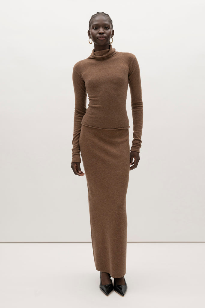 Brown Olivia Turtleneck Delicately soft and consciously crafted, it's the perfect foundation for any outfit.-Classic turtleneck silhouette -Extra-long neck trim for versatile styling (folding and stacking)-Long sleeves designed for slight stacking at the wrist-Rolled wrist and bottom hem 🐑 Made with Good Cashmere Standard® wool to support the welfare of cashmere goats We recommend ordering your usual size.Styled with the Ava Skirt