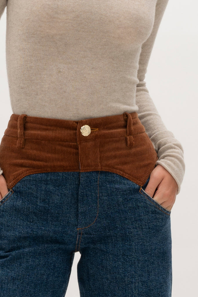 Medium Indigo Torrey Jean Featuring combination fabrics and crafted from premium Japanese denim, these novelty pants elevate the classic wide-leg silhouette with unexpected details.-Premium Japanese denim -Signature corset style waistband in contrasting corduroy fabric -Wide leg-Flannel-lined at waist -Corduroy faced cuffs at bottom hem -Pockets at front and back-Gold knot button closure -Zip-fly ♻️ Environmentally conscious: Made with up-cycled Japanese denim that is produced with reduced CO2 emissions and water-conserving processes. We recommend ordering your usual size.Styled with the Torrey Jacket & Olivia Turtleneck 