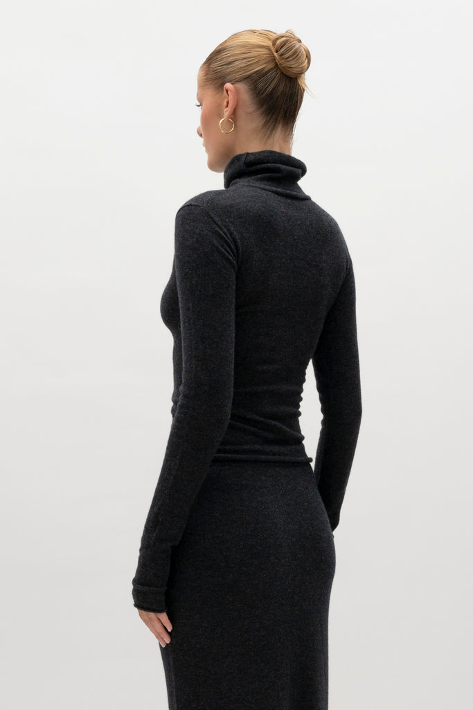 Charcoal Olivia Turtleneck Delicately soft and consciously crafted, it's the perfect foundation for any outfit.-Classic turtleneck silhouette -Extra-long neck trim for versatile styling (folding and stacking)-Long sleeves designed for slight stacking at the wrist-Rolled wrist and bottom hem 🐑 Made with Good Cashmere Standard® wool to support the welfare of cashmere goats We recommend ordering your usual size.Styled with the Ava Skirt