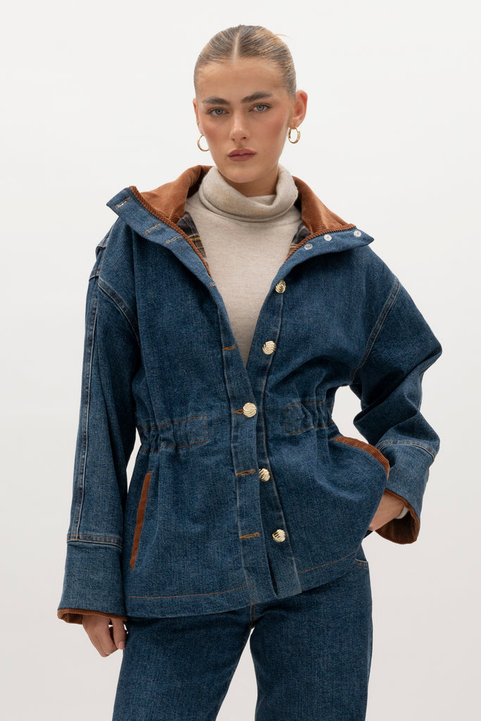 Medium Indigo Torrey Jacket A corduroy collar and gold buttons elevate this classic silhouette, while a drawcord waist lets you personalize the fit. Perfect for layering. -Premium Japanese denim-Cinched-waist jacket-Corduroy-faced collar-Funnel neck-Drawcord tunnel at waist-Welt pockets at front-Self-fabric placket with gold knot buttons-Corduroy faced cuff for option to roll-Flannel lined interior♻️ Environmentally conscious: Made with up-cycled Japanese denim that is produced with reduced CO2 emissions and water-conserving processes. We recommend ordering your usual size.Styled with the Torrey Jean & Olivia Turtleneck  