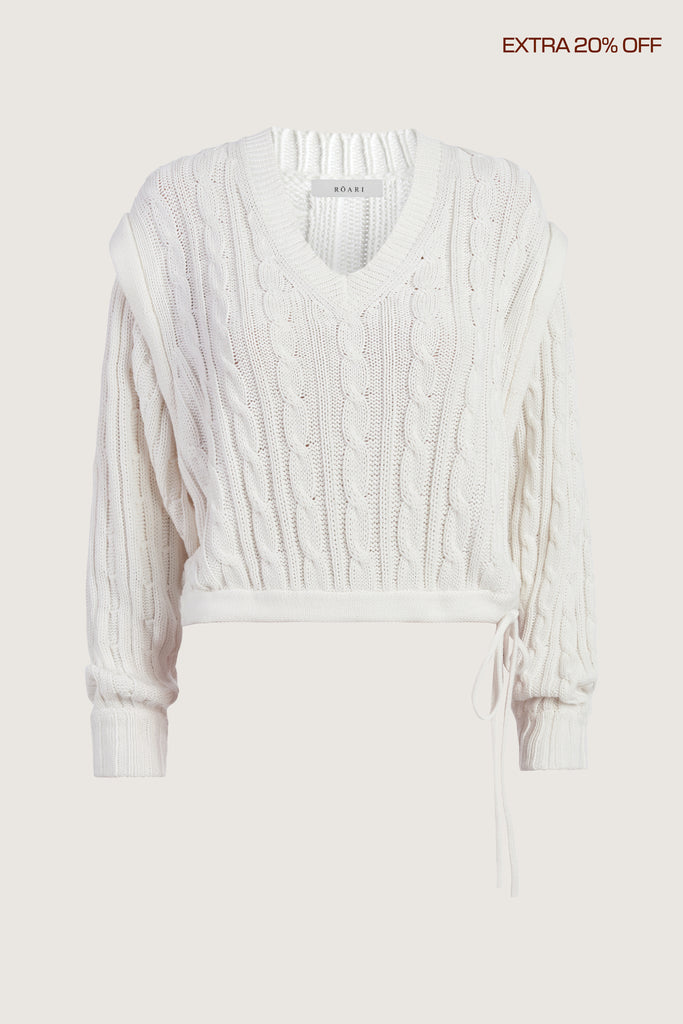  Isabel Sweater Made with 100% cotton yarn, this convertible cable knit sweater features hidden snaps for the option to remove the sleeves. Knit draw cord at waist for choice to cinch or neatly tuck into your favorite jeans. A quintessential seasonless piece.*The top left and right of the removable sleeves will have either a red or white small sewn on marker, indicating which sleeve goes where for ease when placing back on.Ingryd is 5'10