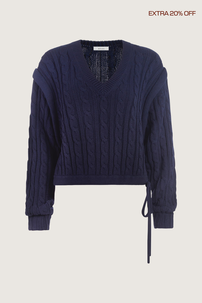  Isabel Sweater Made with 100% cotton yarn, this convertible cable knit sweater features hidden snaps for the option to remove the sleeves. Knit draw cord at waist for choice to cinch or neatly tuck into your favorite jeans. A quintessential seasonless piece.*The top left and right of the removable sleeves will have either a red or white small sewn on marker, indicating which sleeve goes where for ease when placing back on.Ingryd is 5'10