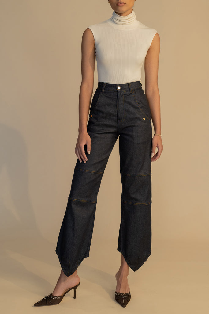 Raw Indigo Quinn Jean High-rise relaxed straight leg jean featuring drop pockets with snap closure, v-shaped front hem, and buttons at back for option to cinch at ankle. Each pair has a branded enameled button. 