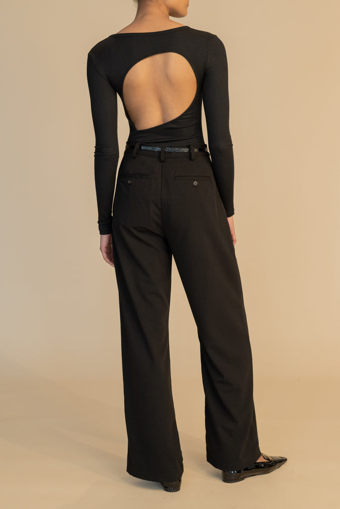 Black Kat Trouser Dual pleated mid-rise trousers featuring a straight relaxed fit, pockets at back with horn buttons, and includes a self-fabric detachable belt. 