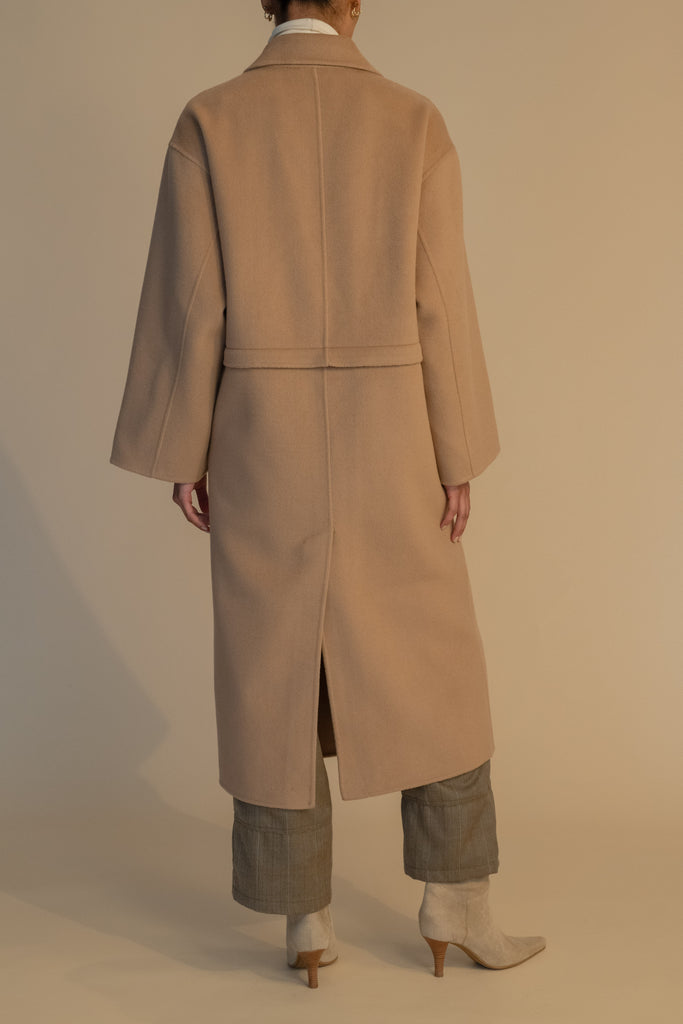 Camel EVELYN COAT This convertible coat features a low double breasted front with horn buttons and dropped shoulders. Purposefully designed oversized to allow for comfortable layering. Zipper above welt side pockets allows to double as a cropped jacket. 