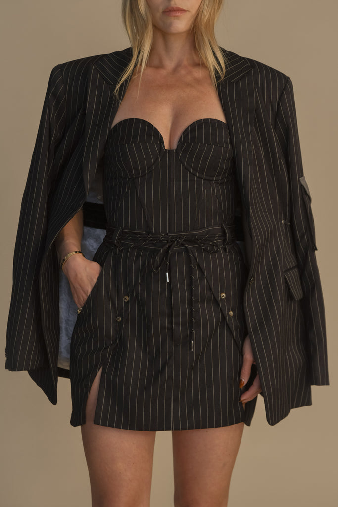 Navy Pinstripe BAMBI DRESS This wrap dress features a fixed belt at waist and plunging open back. Crafted from a stretch ponte fabric, hidden zips at sides provide option to vent. Size down for a snug fit.*All sale merchandise is exchangeable for size only. 