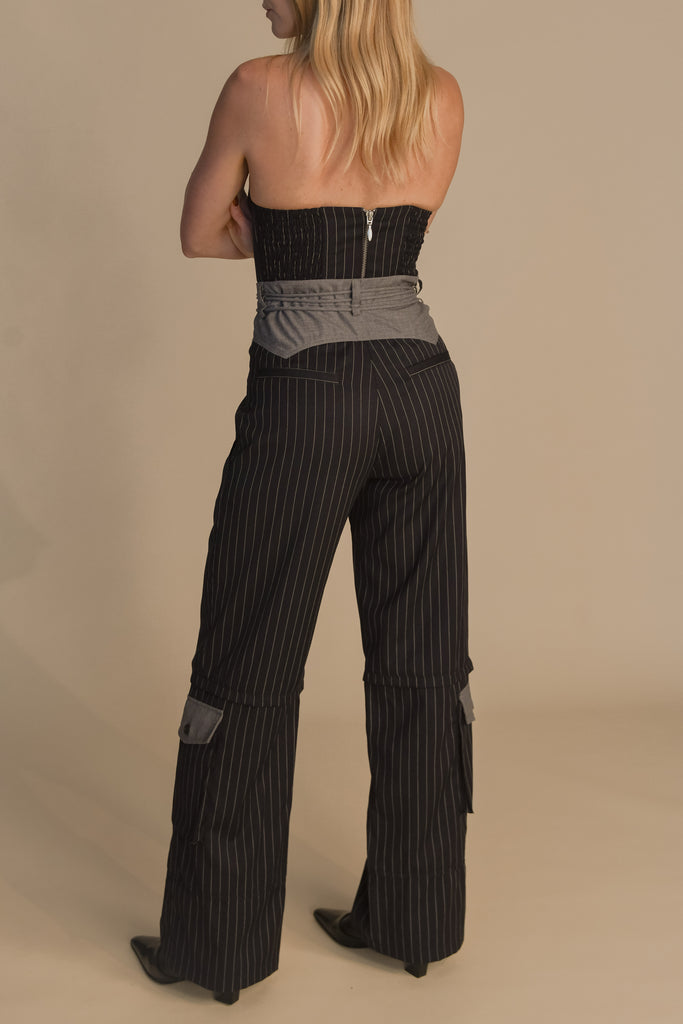 Navy Pinstripe Ronnie Corset This tailored strapless corset features a fitted suiting bodice with contoured boning, moldable wiring at cups, and shirred back panels to ensure a snug yet flexible fit. Slightly cropped with a v-front silhouette.