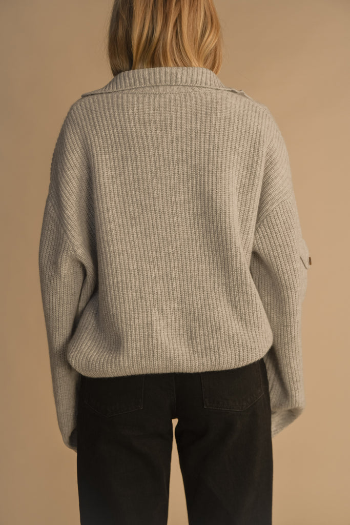 Heather Grey GRAHAM CARIDGAN This 100% royal cashmere cardigan features an oversized silhouette that hits below the hip, perfect for layering. Features horn buttons along with pockets at chest and right sleeve. Can be worn open or buttoned up as a turtleneck.