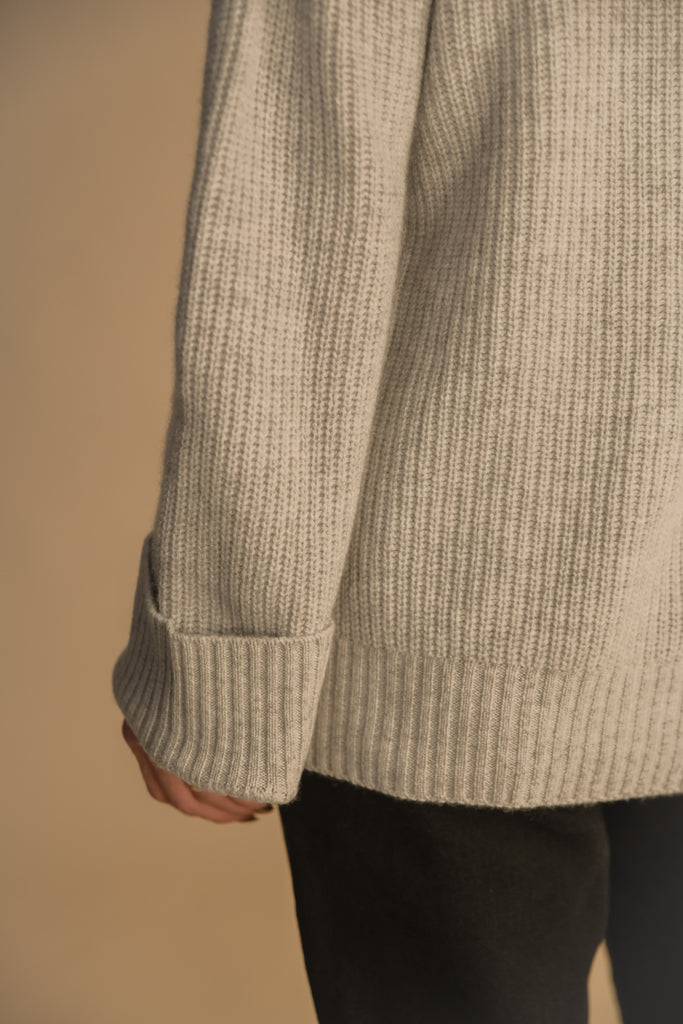 Heather Grey GRAHAM CARIDGAN This 100% royal cashmere cardigan features an oversized silhouette that hits below the hip, perfect for layering. Features horn buttons along with pockets at chest and right sleeve. Can be worn open or buttoned up as a turtleneck.