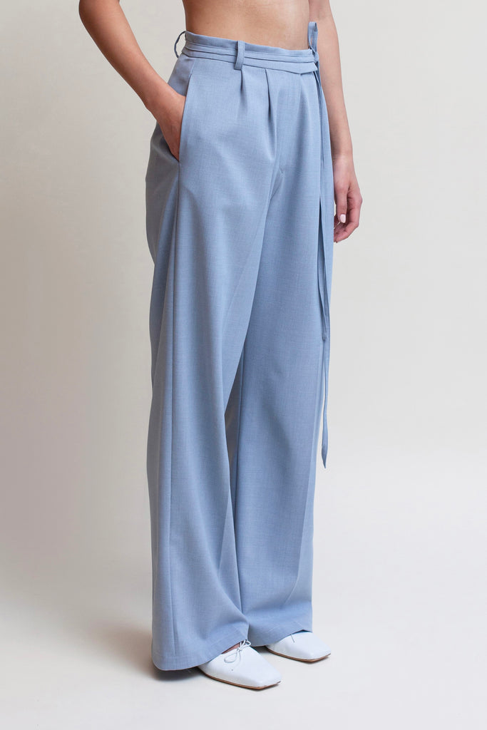 Stone Blue Kat Trouser Dual pleated mid-rise trousers featuring a straight, relaxed fit. Pockets at back with horn buttons. Includes a self-fabric detachable belt. *Sale merchandise is exchangeable for size or store credit. 
