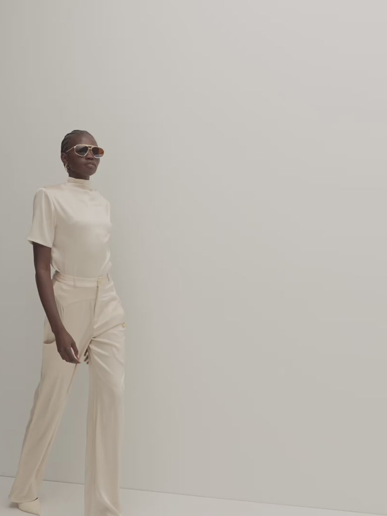 Champagne Vivien Top -Cowl neckline with stacked collar-Self-loop and gold knot button at back neck-Removable shoulder pads with interior pockets -French seams for clean finish-1/4” baby hem on sleeves and body-Fluid drape with tailored structure Anok is 5'9