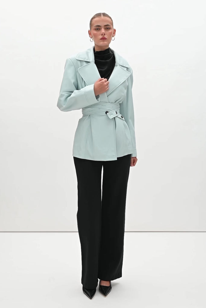Powder Blue Kennedy Trench Handcrafted from soft vegan leather, the Kennedy trench showcases sharp collars and clean lines. The cinched waist with buttoned belt offers a customizable fit.-Hidden stay button closure-Double wrap belt-Bracelet-length sleeve-On seam front pockets-Fully lined Handcrafted in small batches by our expert leather artisan in New York City.We recommend sizing up if a relaxed fit is desired otherwise choose your usual size.Styled with the Vivien LS Top & Mia Trouser