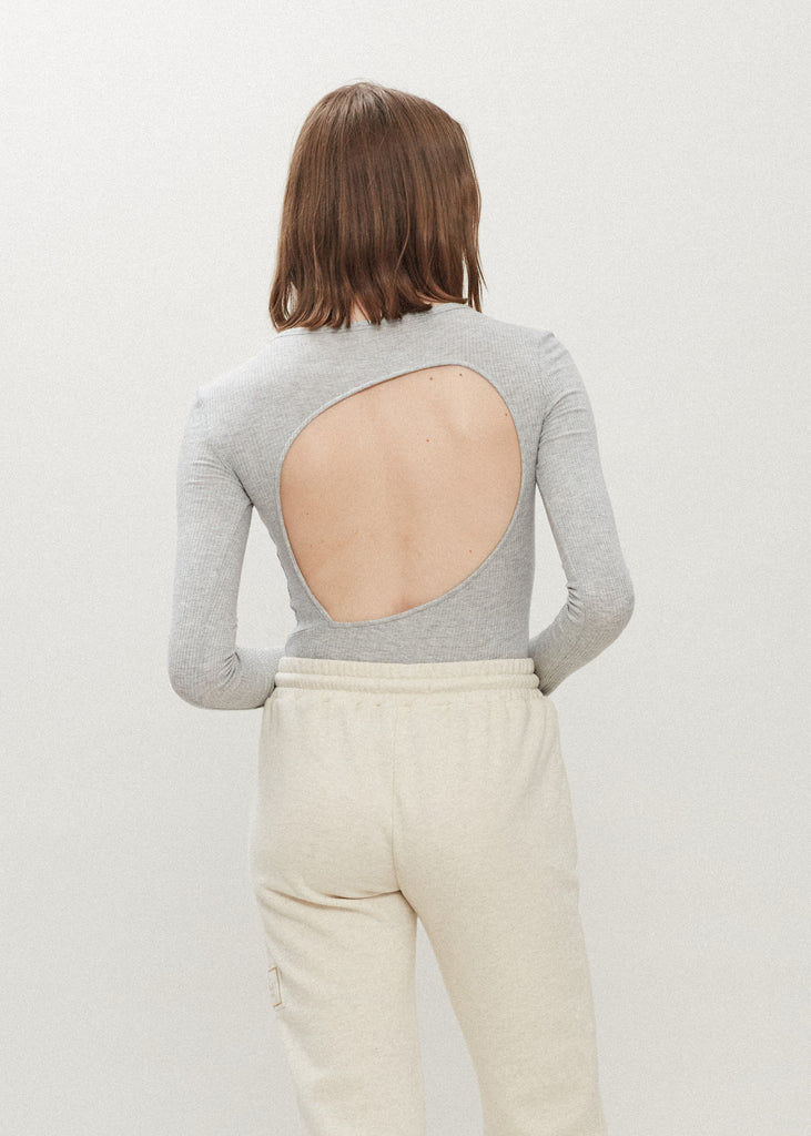Light Grey Baby Bodysuit This buttery soft long sleeved bodysuit features a sleek silhouette with a crew neckline and an asymmetrical bold back cutout.FINAL SALE 