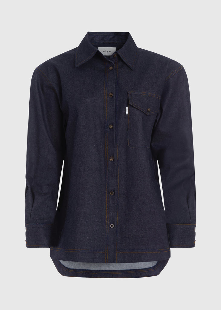 Raw Indigo Charlie Shirt This oversized button down is crafted from lightweight denim designed to feel weightless and breathable during all seasons with a drapey yet structured silhouette. Its relaxed fit is finished with traditional denim stitching and horn buttons. Features a RŌARI branded deco label at chest pocket.Styled with The Chloe Corset