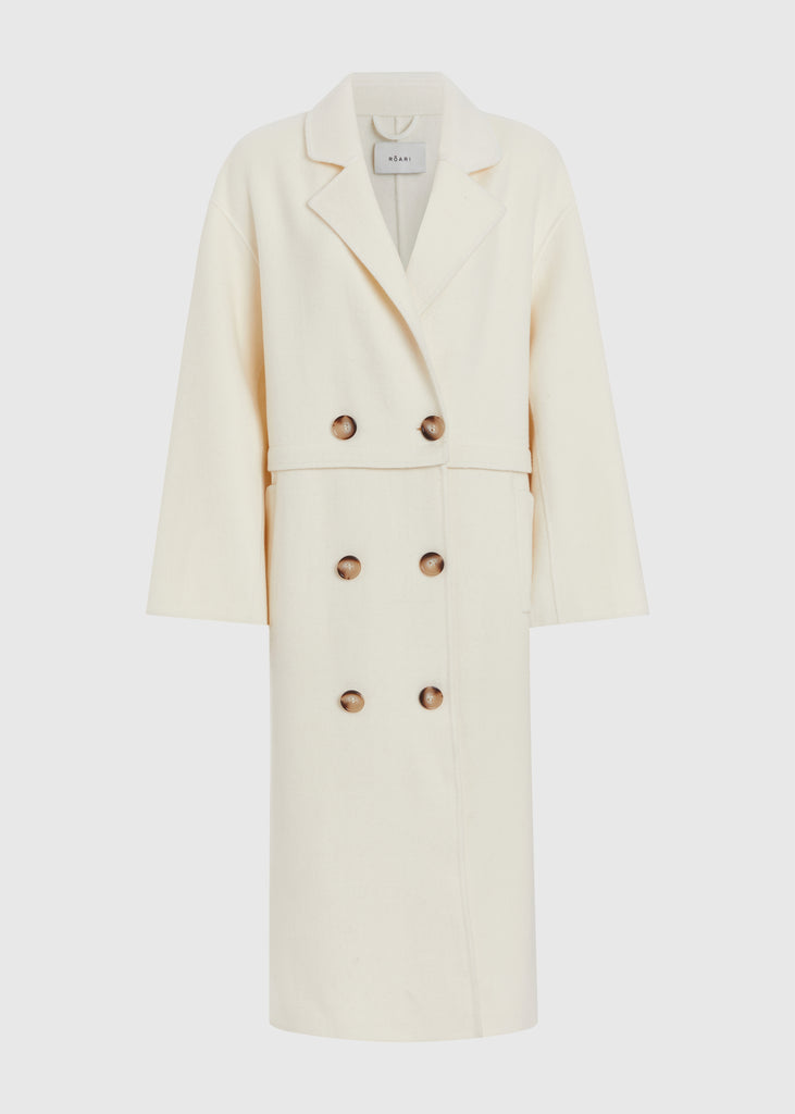 Bone Evelyn Coat This convertible coat features a low double breasted front with horn buttons and dropped shoulders. Purposefully designed oversized to allow for comfortable layering. Zipper above welt side pockets allows to double as a cropped jacket. 