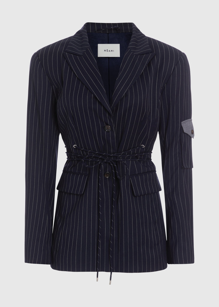 Navy Pinstripe Ronnie Blazer Oversized 90's inspired blazer featuring a fixed self-fabric waist tie, cargo pocket detail on left sleeve, two standard flap pockets at hips, and custom selected horn buttons.