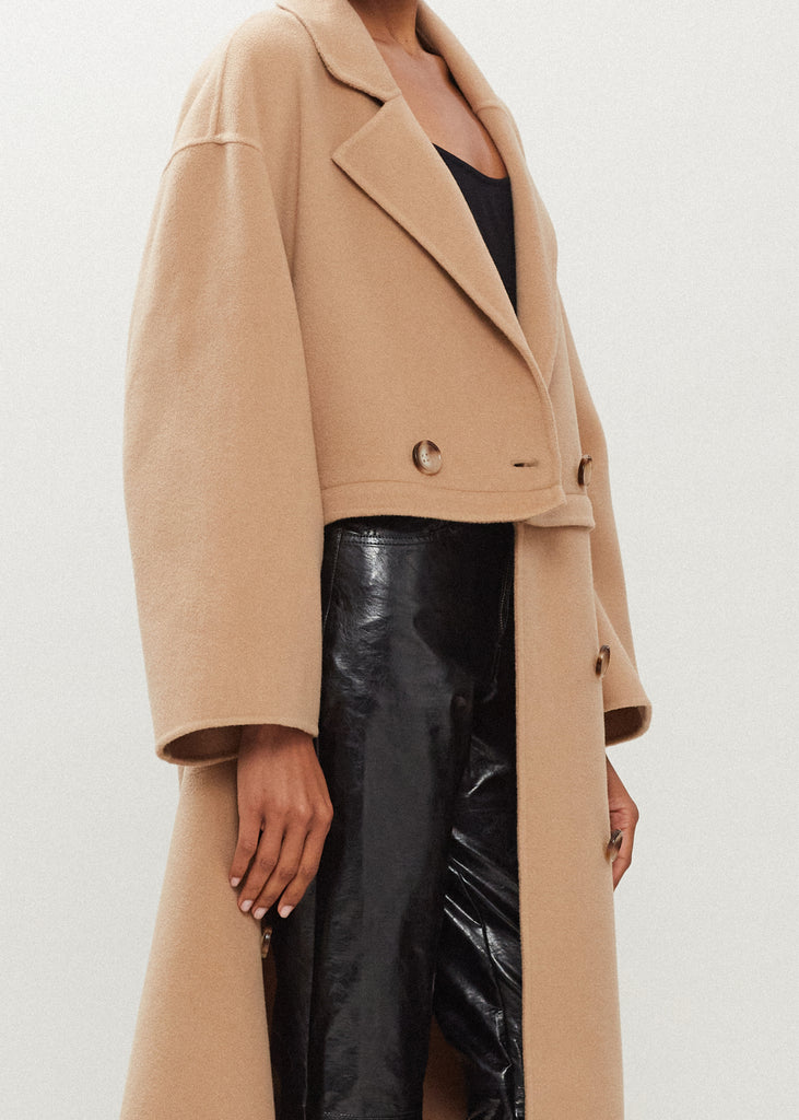Camel Evelyn Coat This convertible coat features a low double breasted front with horn buttons and dropped shoulders. Purposefully designed oversized to allow for comfortable layering. Zipper above welt side pockets allows to double as a cropped jacket. 