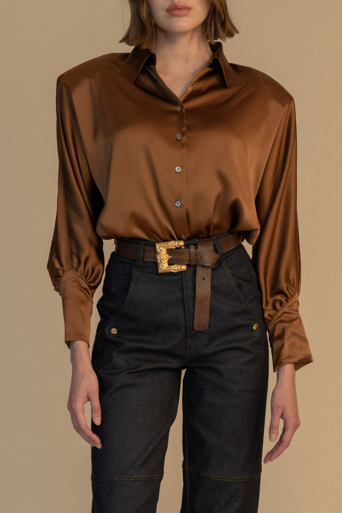 Cinnamon MARNA SHIRT A silky button down featuring blouson sleeves. Composed of wrinkle resistant vegan silk, this top includes mother of pearl buttons, concealed zippers at wrists, and removable shoulder pads.  