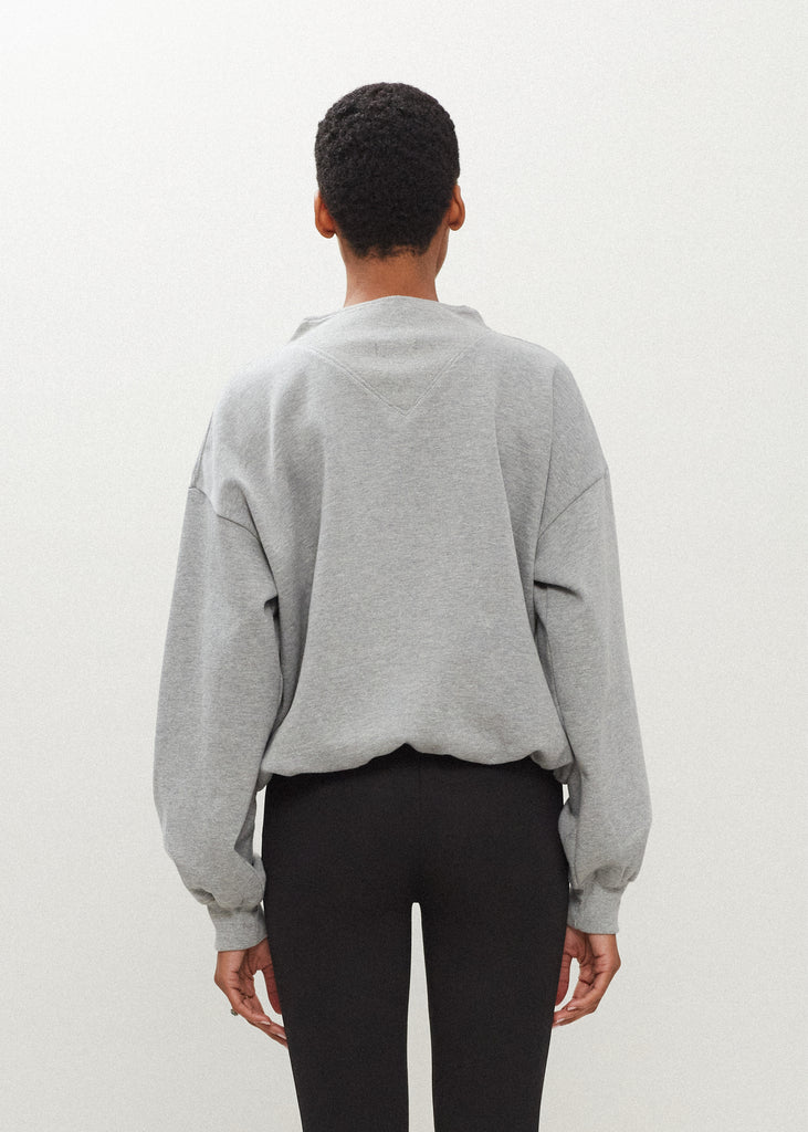 Heather Grey Henry Sweatshirt This half-zip pullover features a ribbed v-neckline, branded patch logo and side pockets. 