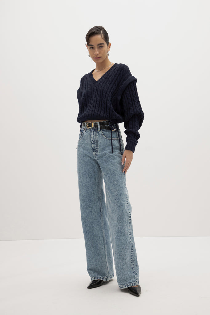 Navy Isabel Sweater Made with 100% cotton yarn, this convertible cable knit sweater features hidden snaps for the option to remove the sleeves. Knit draw cord at waist for choice to cinch or neatly tuck into your favorite jeans. A quintessential seasonless piece.*The top left and right of the removable sleeves will have either a red or white small sewn on marker, indicating which sleeve goes where for ease when placing back on. Ingryd is 5'10