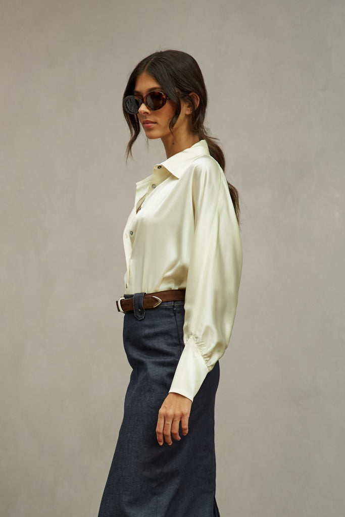 Bone Marna Shirt A silky button down featuring blouson sleeves. Composed of wrinkle resistant vegan silk, this top includes mother of pearl buttons, concealed zippers at wrists, and removable shoulder pads. 