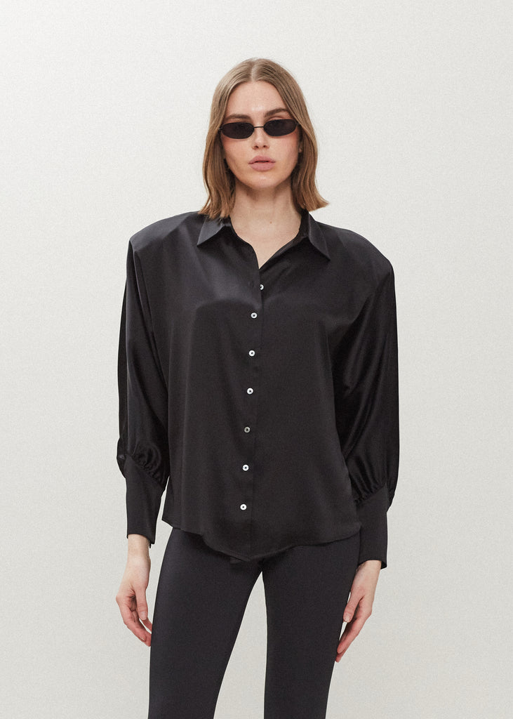 Black Marna Shirt A silky button down featuring blouson sleeves. Composed of wrinkle resistant vegan silk, this top includes mother of pearl buttons, concealed zippers at wrists, and removable shoulder pads.  