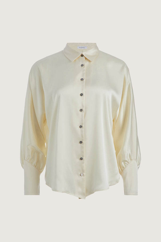 Bone Marna Shirt A silky button down featuring blouson sleeves. Composed of wrinkle resistant vegan silk, this top includes mother of pearl buttons, concealed zippers at wrists, and removable shoulder pads. All items marked down are FINAL SALE.