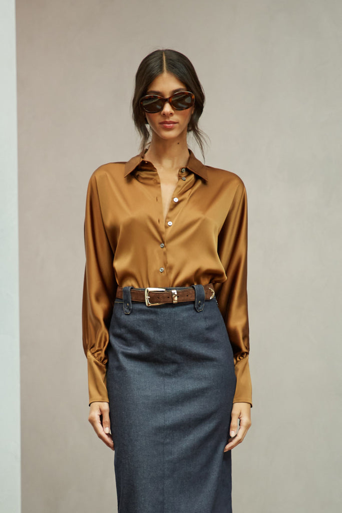 Cinnamon Marna Shirt A silky button down featuring blouson sleeves. Composed of wrinkle resistant vegan silk, this top includes mother of pearl buttons, concealed zippers at wrists, and removable shoulder pads. 