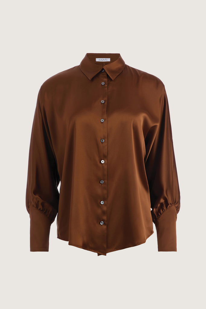 Cinnamon Marna Shirt A silky button down featuring blouson sleeves. Composed of wrinkle resistant vegan silk, this top includes mother of pearl buttons, concealed zippers at wrists, and removable shoulder pads. All items marked down are FINAL SALE.