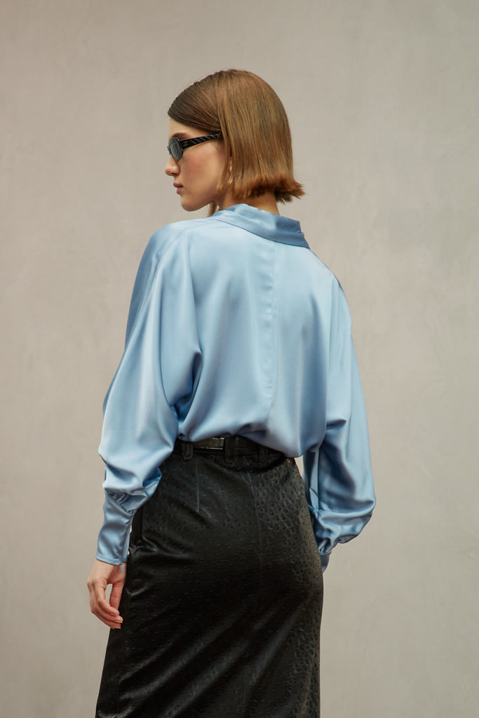 Sky Marna Shirt A silky button down featuring blouson sleeves. Composed of wrinkle resistant vegan silk, this top includes mother of pearl buttons, concealed zippers at wrists, and removable shoulder pads. 