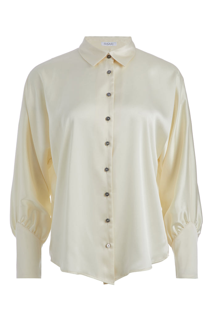 Bone Marna Shirt A silky button down featuring blouson sleeves. Composed of wrinkle resistant vegan silk, this top includes mother of pearl buttons, concealed zippers at wrists, and removable shoulder pads.  